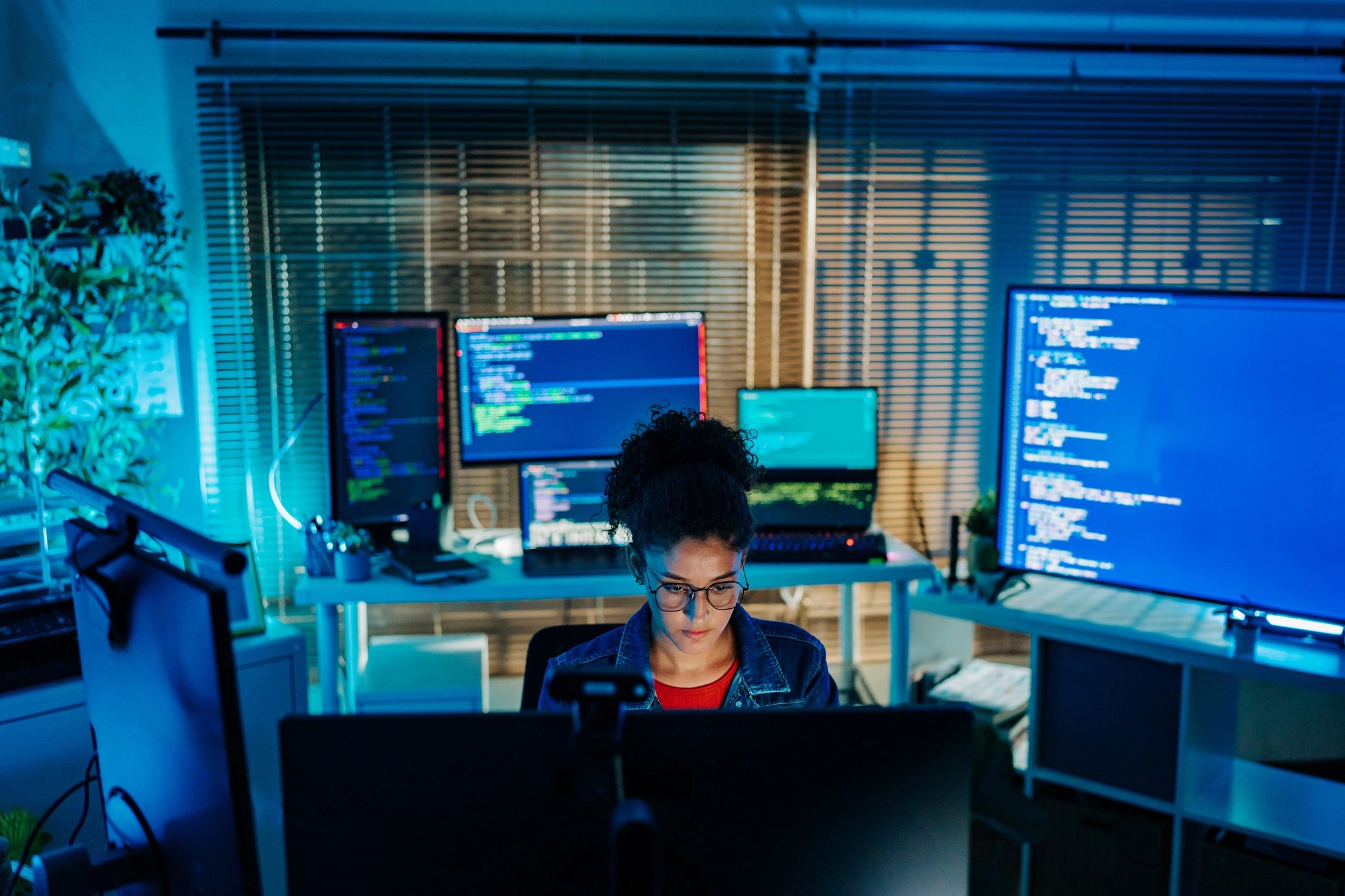 Software developer coding at a multi-monitor workstation
